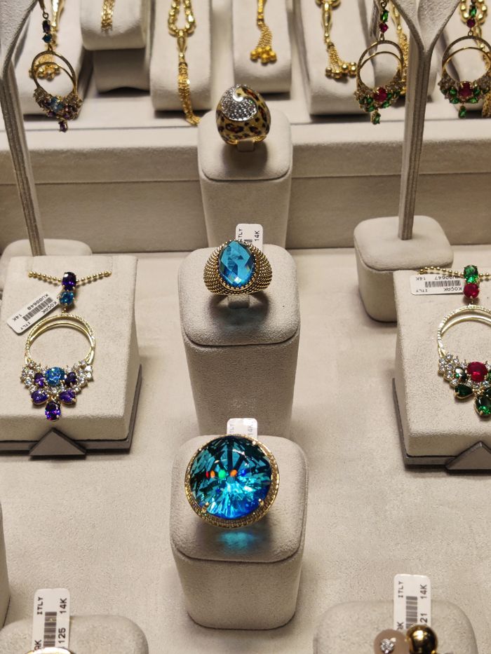 Showcasing a collection of exquisite luxury rings with gemstones in a display case.