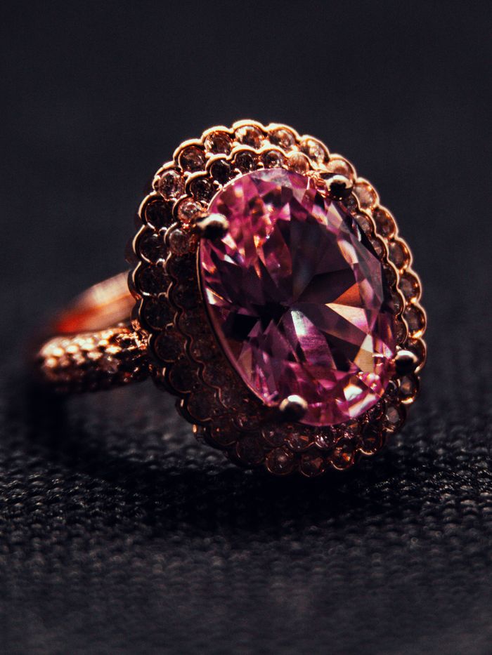 Close-up of a luxurious pink gemstone ring set in intricate gold detailing.